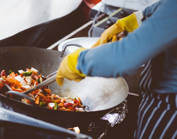 closeup of woman cooking with a wok