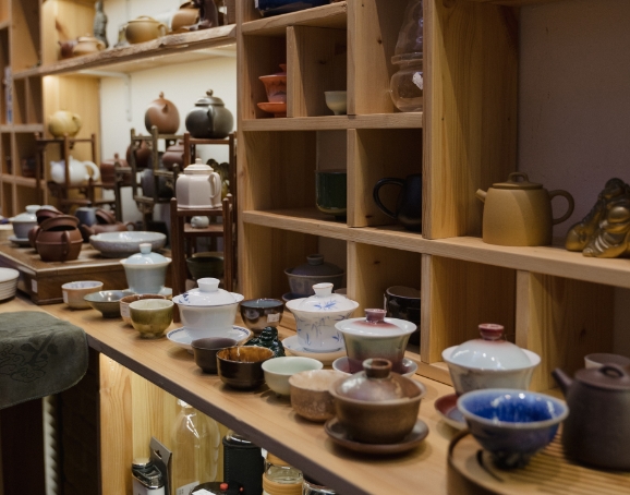 shelf showcasing various tea cups and pots